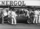 38a. F2-30. Stirling Moss No20 (GB) Vanwall, leaps out of cockpit to refuel, British GP 1957.