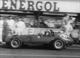 38. F2-11. Mike Hawthorn No10 (GB) Ferrari D50, leaves pitlane drinking a Coke, British GP 1957.