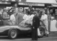 26. F2-5. Tony Brooks No18 (GB) Vanwall, adjusting helmet for race, British GP, Aintree 1957.