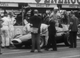 22. F2-26. Stirling Moss No18 (GB) Vanwall, standing in cockpit, British GP, Aintree 1957.